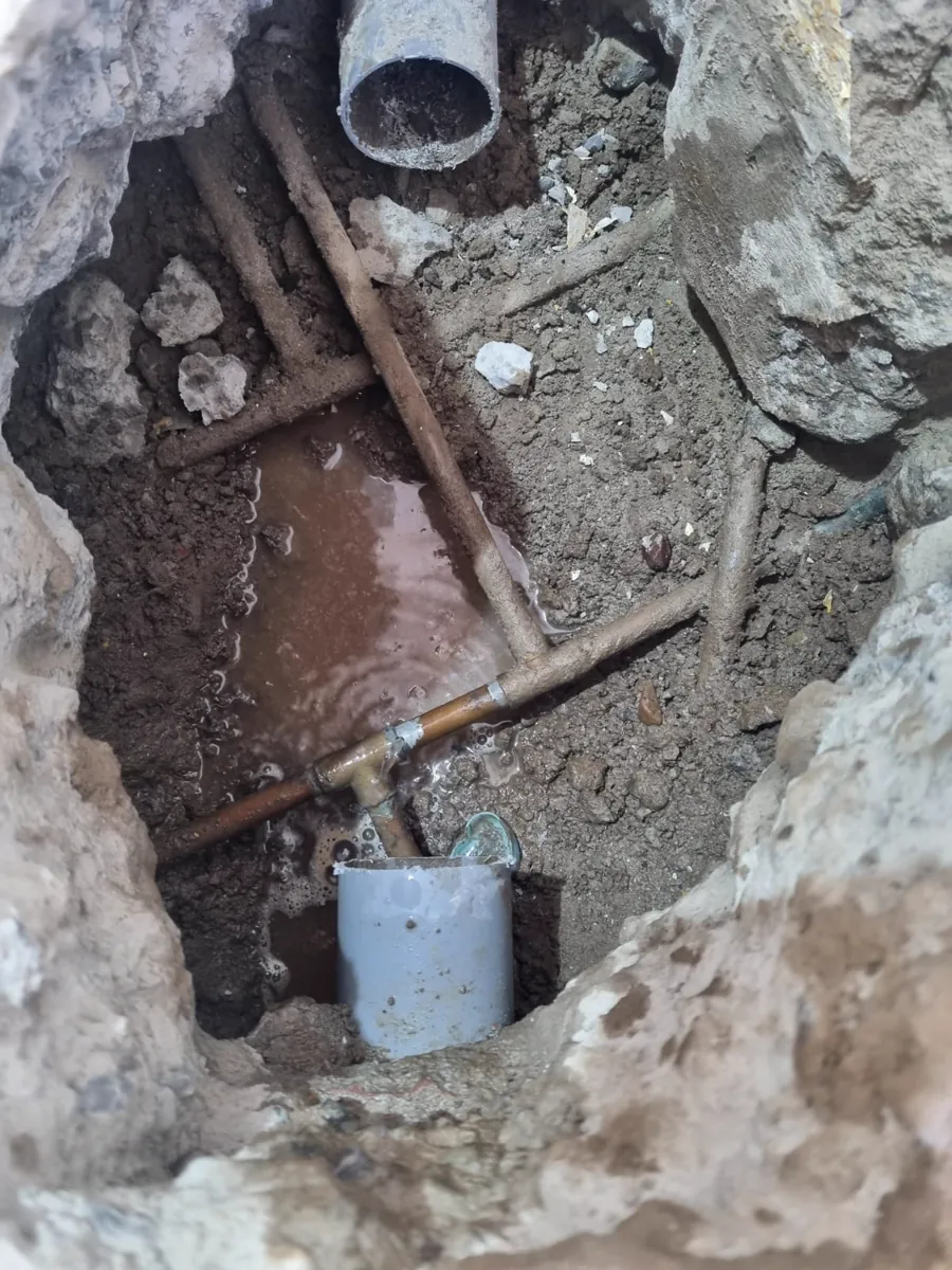 Cañería de cobre picada con agua saliendo